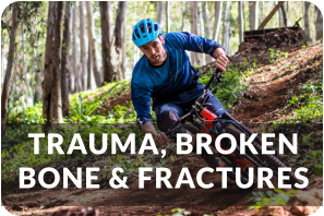 A young man rides down a steep forest trail on his bicycle. He is wearing a helmet and knee pads. Title reads: Trauma, Broken Bones, and Fractures