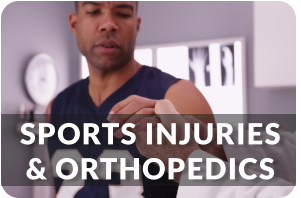 A young man in a sports jersey sits on an exam table as a doctor examines his injured hand. Title reads; Sports Injuries and Orthopedics